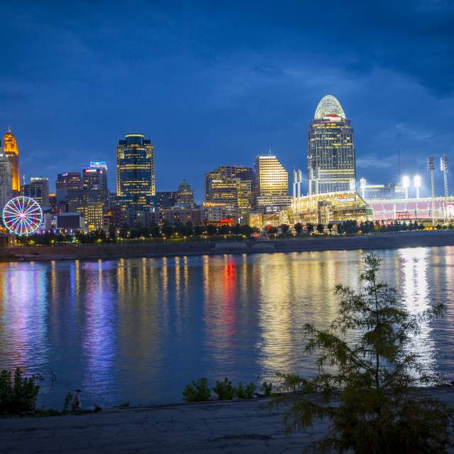 Cincinnati skyline and riverfront glowing at dusk